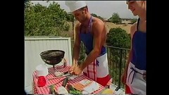 Young Gregg Clarke helps blond s.-hunter Paul Morgan to cook sausages and fish frames on barbeque gr Thumb